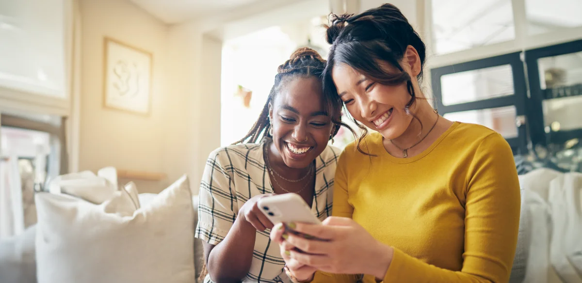 girls looking the phone and smiling